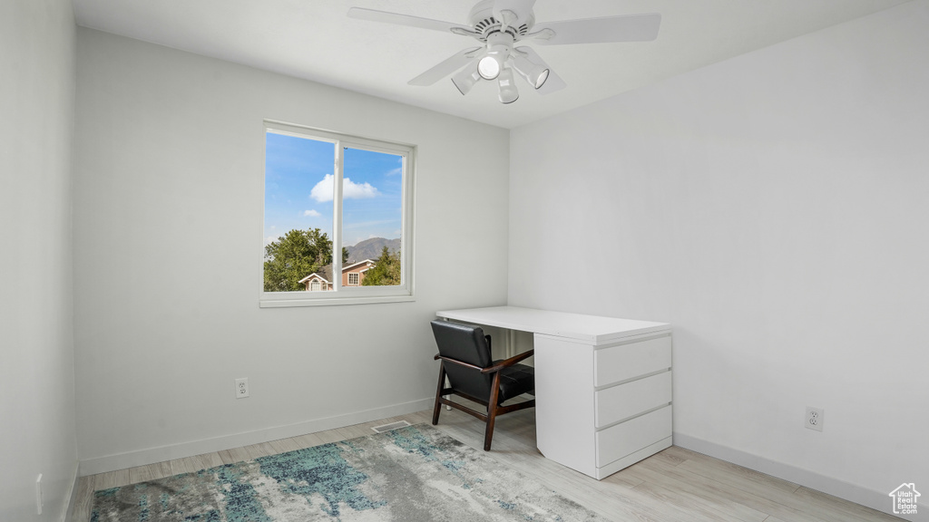 Unfurnished office with light wood finished floors and ceiling fan