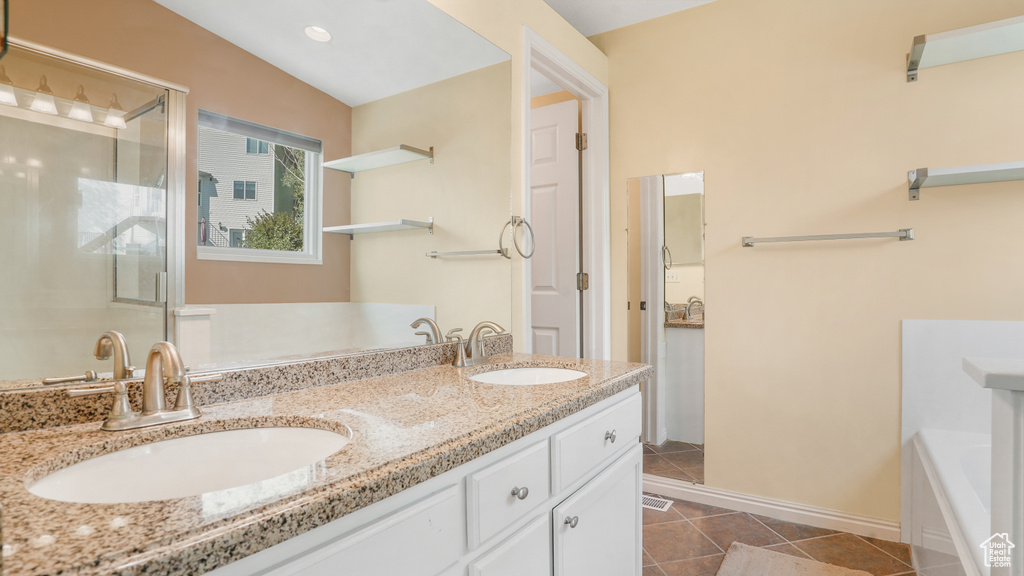 Full bath with tile patterned flooring, a shower stall, a bath, and double vanity