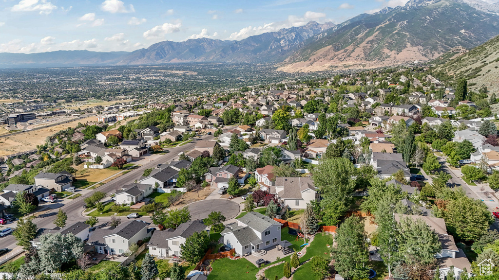 Aerial view of property and surrounding area with a mountain backdrop and nearby suburban area