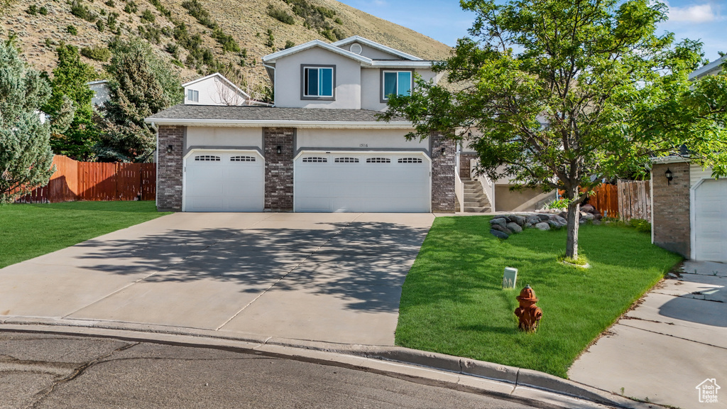 Traditional-style home with concrete driveway, an attached garage, stucco siding, stairs, and a mountain view