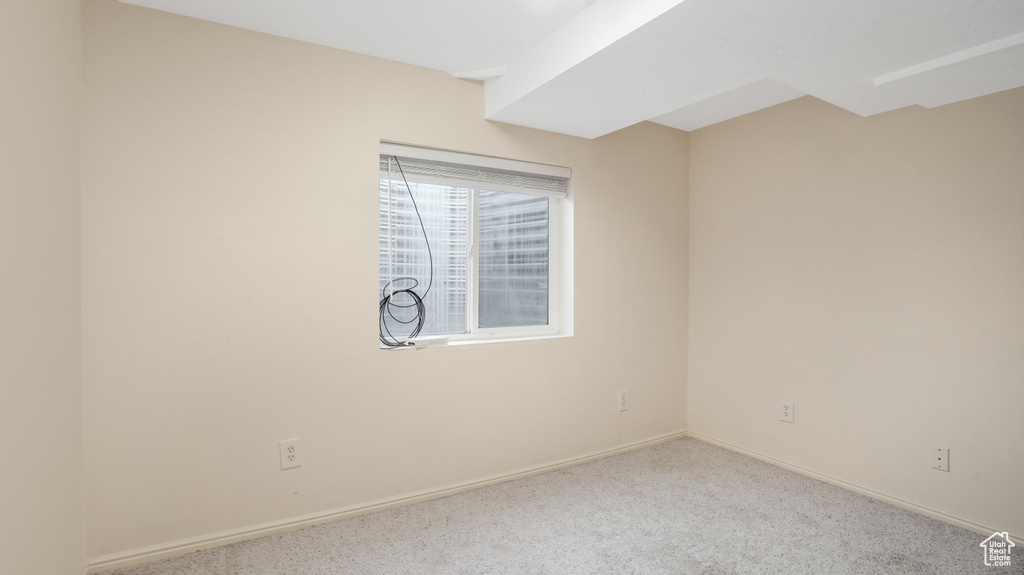 Empty room featuring baseboards and carpet flooring