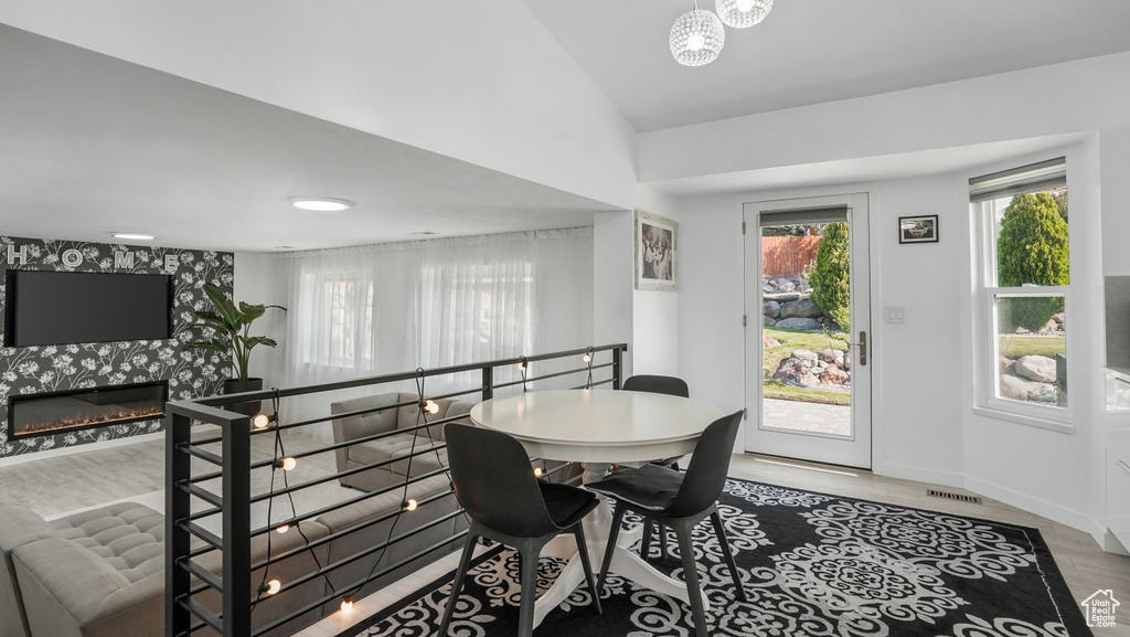 Dining space featuring wood finished floors, a fireplace, and a chandelier