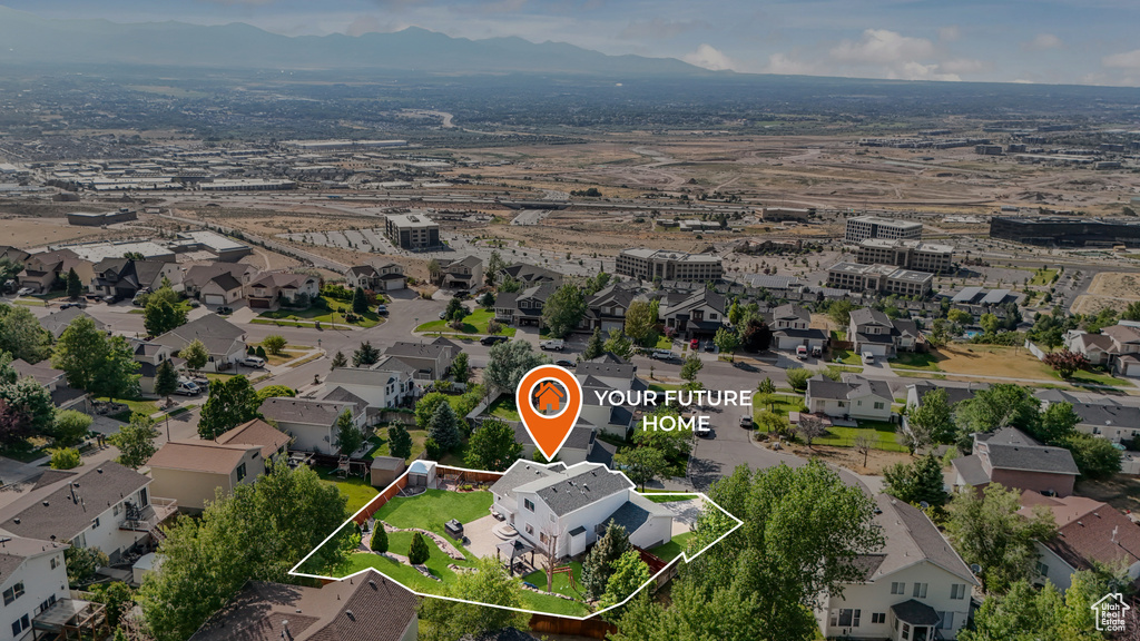 Aerial perspective of suburban area with property parcel outlined and mountains