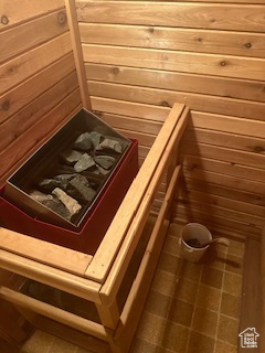 Sauna featuring wood walls and tile patterned floors