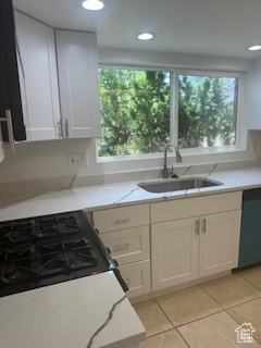 Kitchen featuring light tile patterned flooring, dishwasher, white cabinetry, light stone counters, and recessed lighting