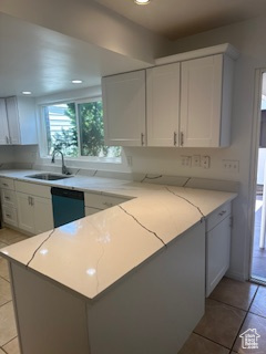 Kitchen featuring light tile patterned floors, white cabinetry, dishwasher, light stone counters, and recessed lighting