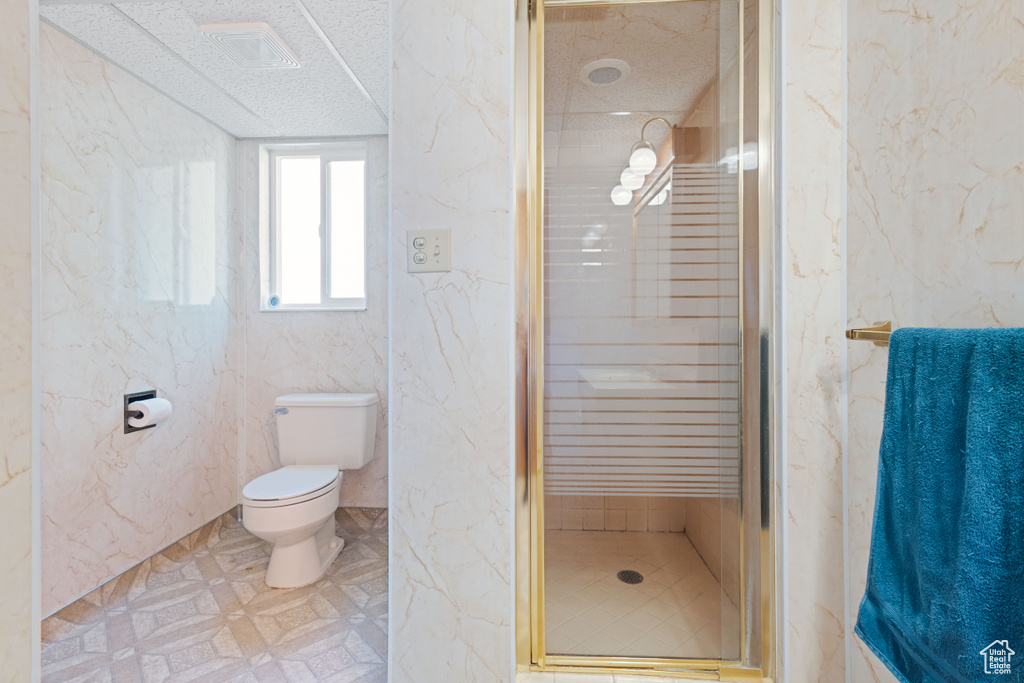 Full bath featuring a stall shower and a textured ceiling