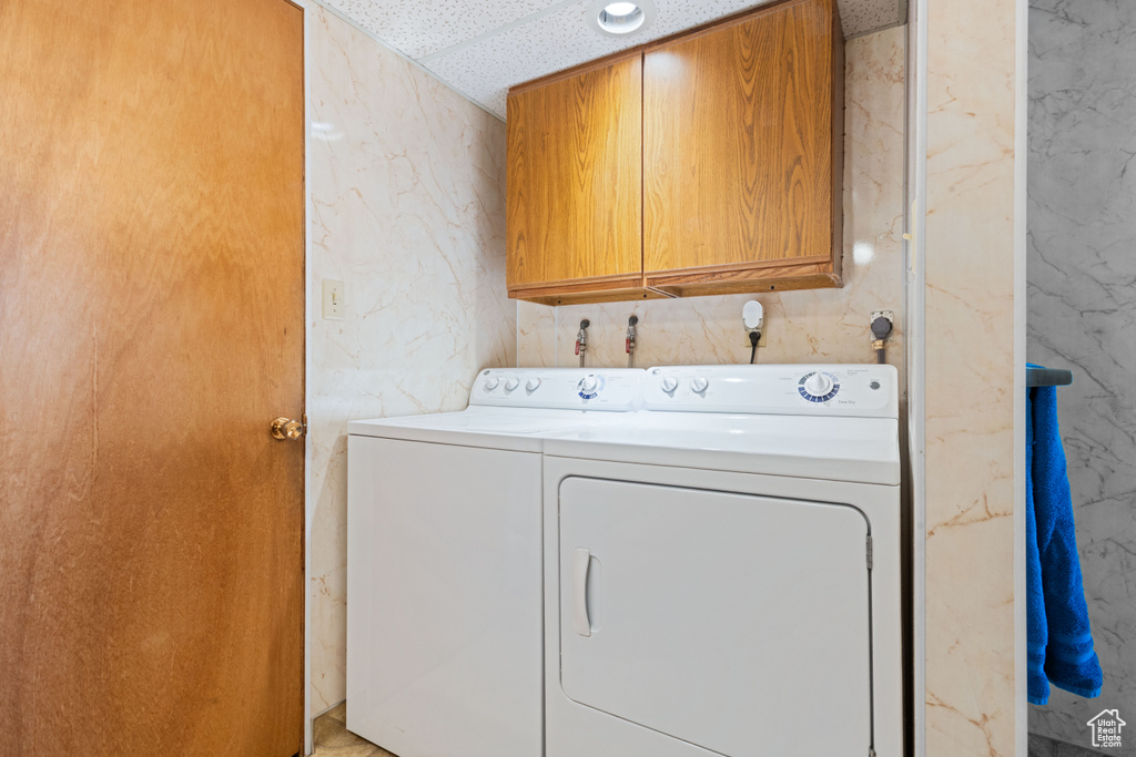 Washroom featuring cabinet space and separate washer and dryer