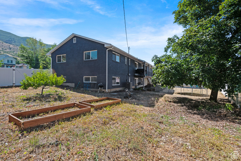 Rear view of house featuring a vegetable garden and a mountain view