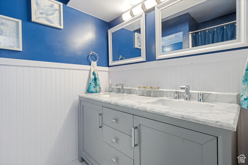 Bathroom featuring double vanity and a wainscoted wall