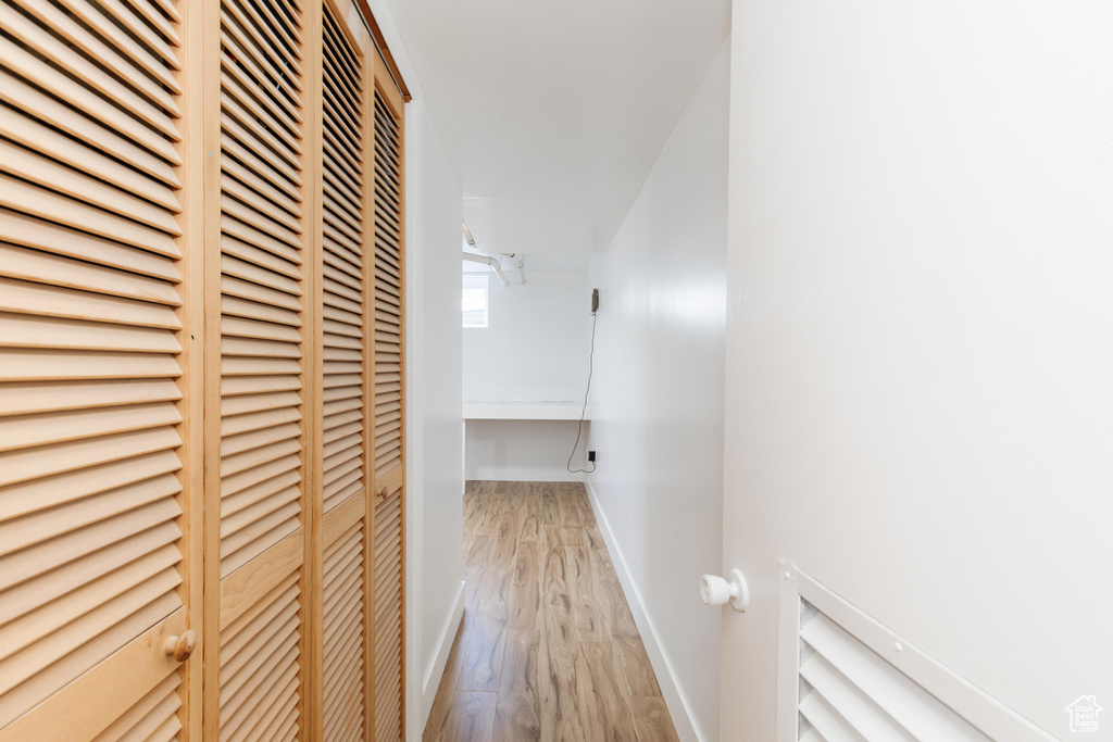 Hall with baseboards and wood finished floors