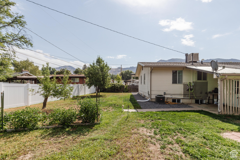 Fenced backyard featuring a mountain view and a patio