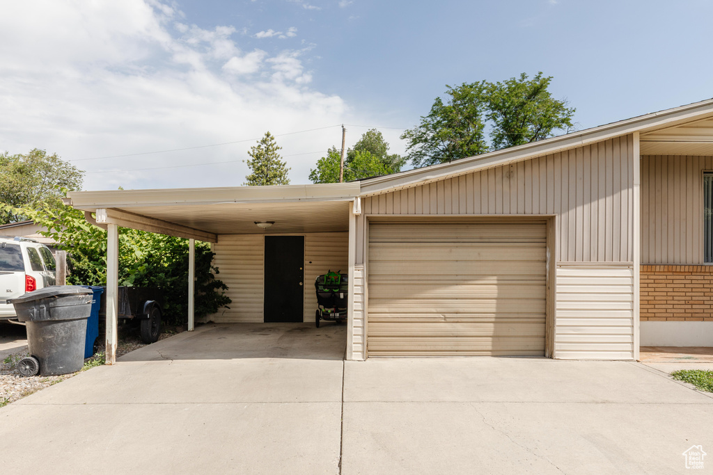 View of front facade with driveway, brick siding, and a garage