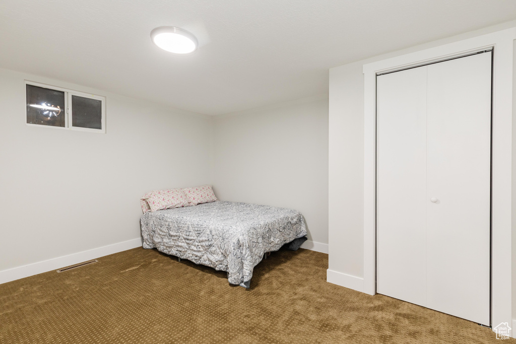 Carpeted bedroom featuring baseboards and a closet