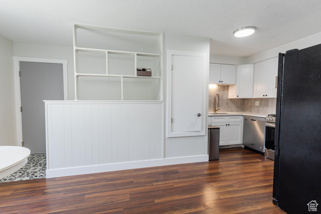 Kitchen featuring freestanding refrigerator, dishwasher, dark wood-style floors, white cabinetry, and light countertops