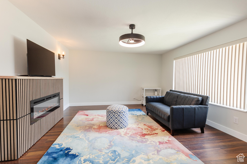 Living area with dark wood finished floors and a glass covered fireplace