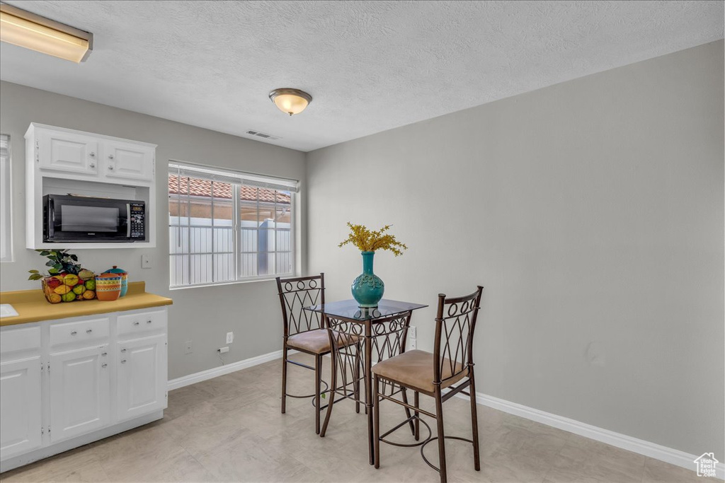 Dining room featuring a textured ceiling and light flooring