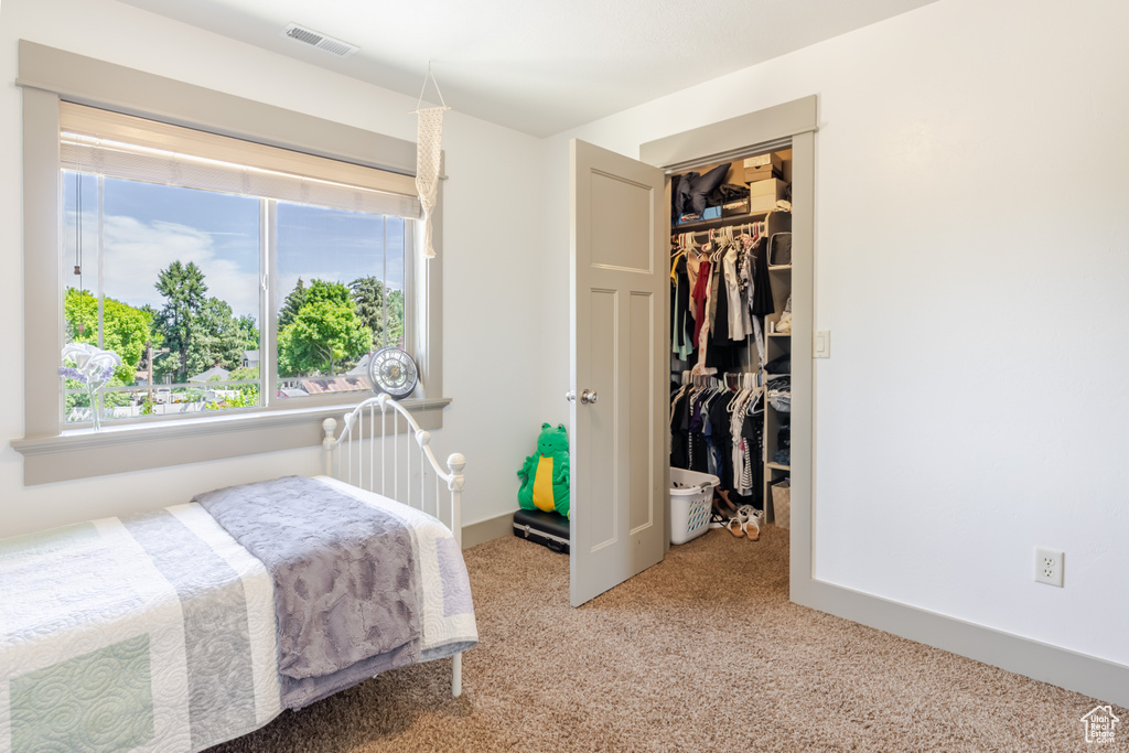 Bedroom with carpet flooring, a closet, and a spacious closet