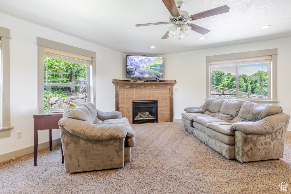 Living room with carpet floors, recessed lighting, a fireplace, and a ceiling fan