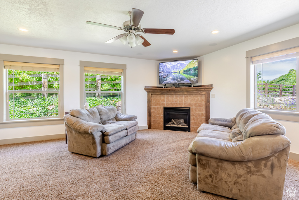 Carpeted living room with a fireplace, a ceiling fan, and recessed lighting