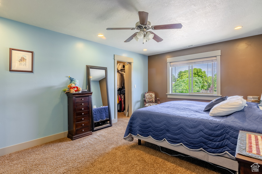 Bedroom featuring a spacious closet, carpet flooring, a closet, ceiling fan, and recessed lighting