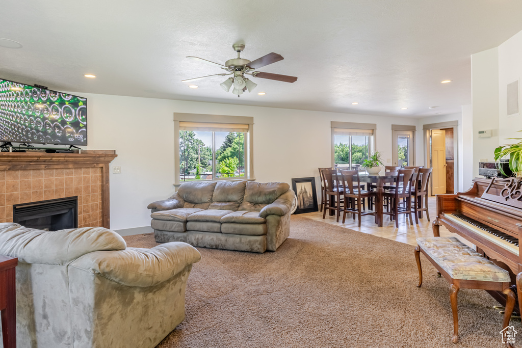 Living room with recessed lighting, a tile fireplace, a ceiling fan, and carpet floors