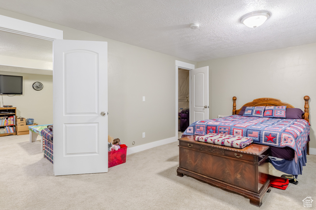 Bedroom featuring carpet floors and a textured ceiling