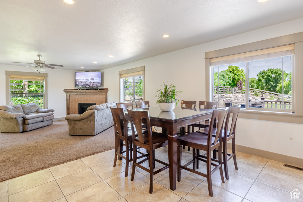 Dining area featuring light tile patterned floors, recessed lighting, light carpet, a fireplace, and a ceiling fan
