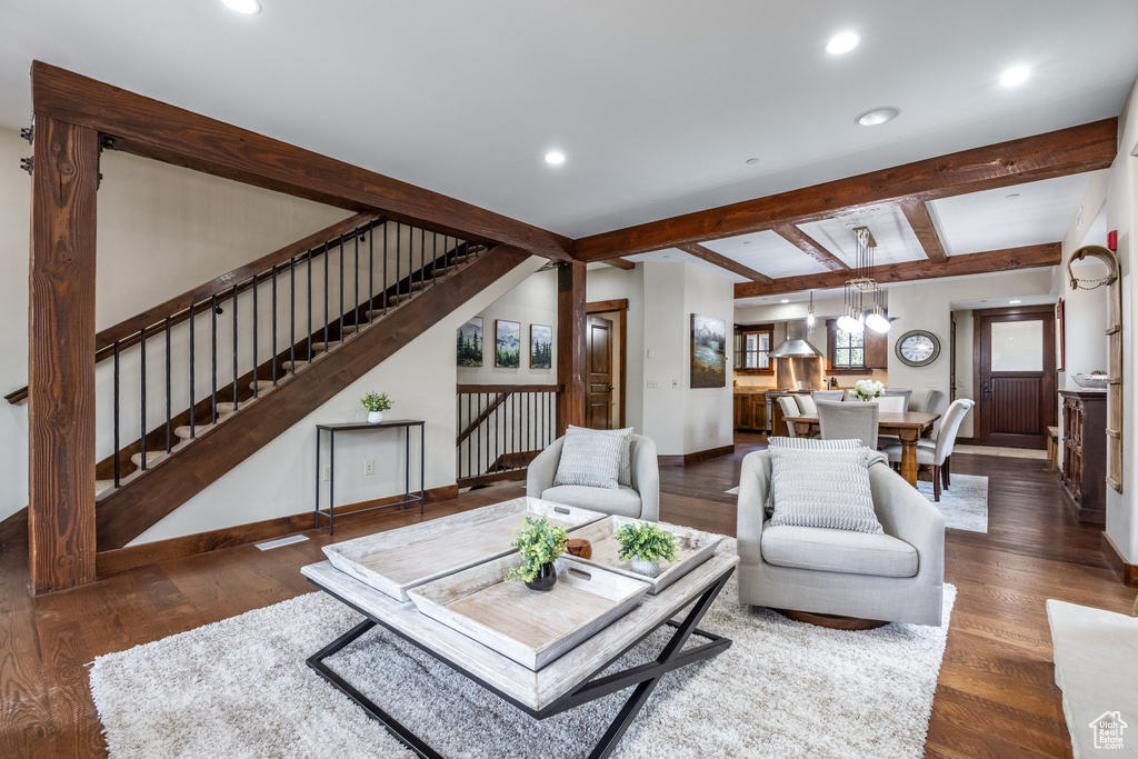 Living room with recessed lighting, stairs, wood finished floors, and beamed ceiling