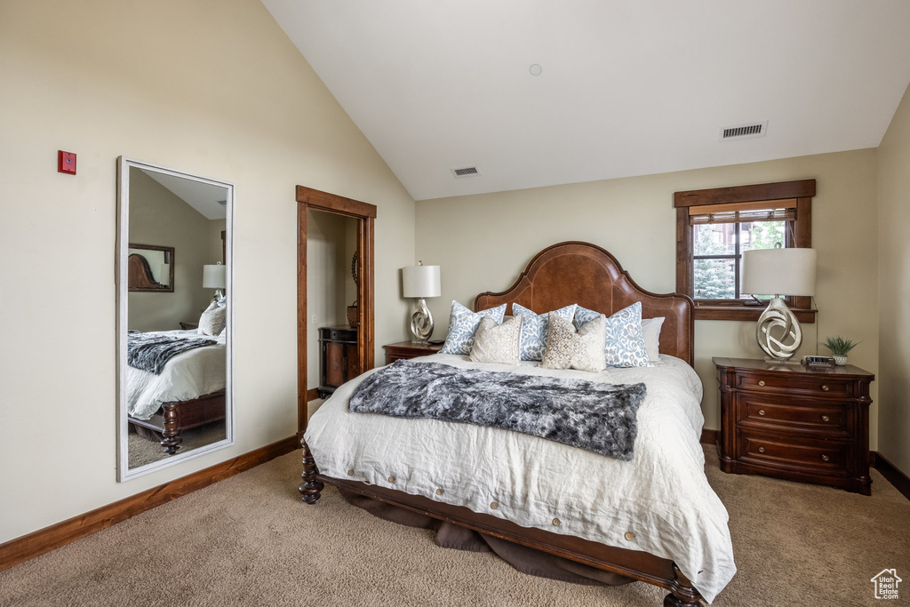 Bedroom with carpet flooring and vaulted ceiling