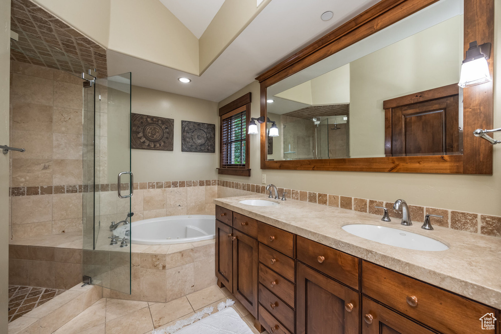 Full bathroom featuring a bath, a stall shower, double vanity, and recessed lighting