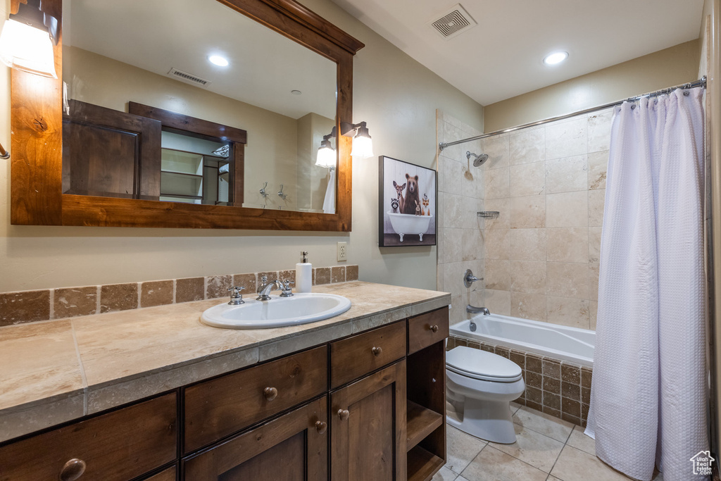 Full bath featuring vanity, tile patterned floors, tiled shower / bath, and recessed lighting