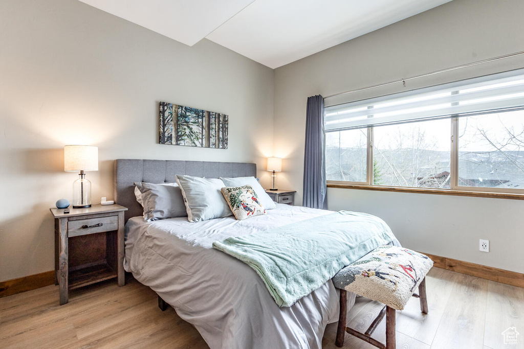 Bedroom with wood finished floors and baseboards