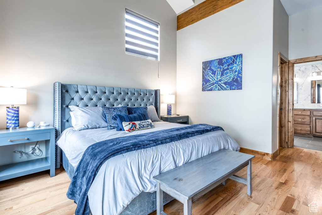 Bedroom with light wood-style floors and ensuite bath