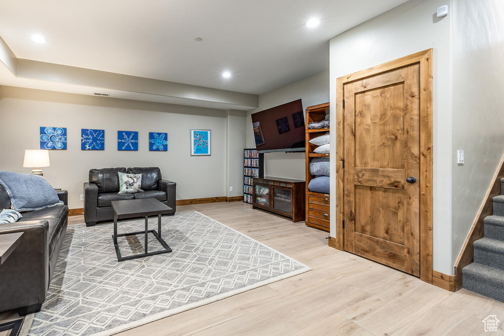 Living area with light wood-style flooring, stairs, and recessed lighting