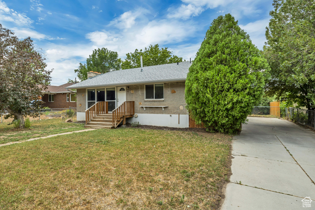 Single story home featuring driveway, a chimney, and a shingled roof