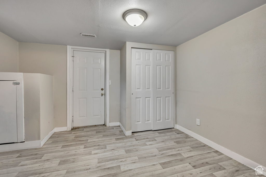 Unfurnished bedroom featuring light wood-style floors and a closet