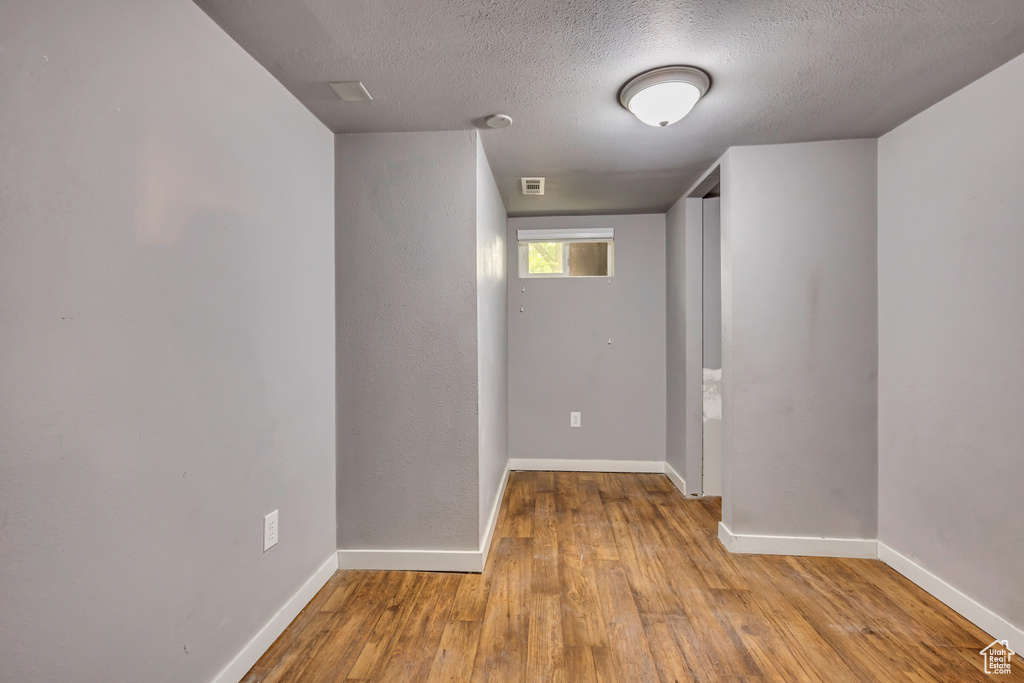 Empty room with wood finished floors and a textured ceiling