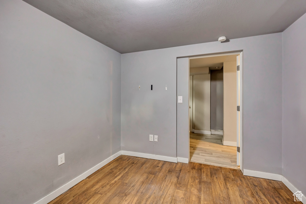 Empty room with wood finished floors and a smoke detector