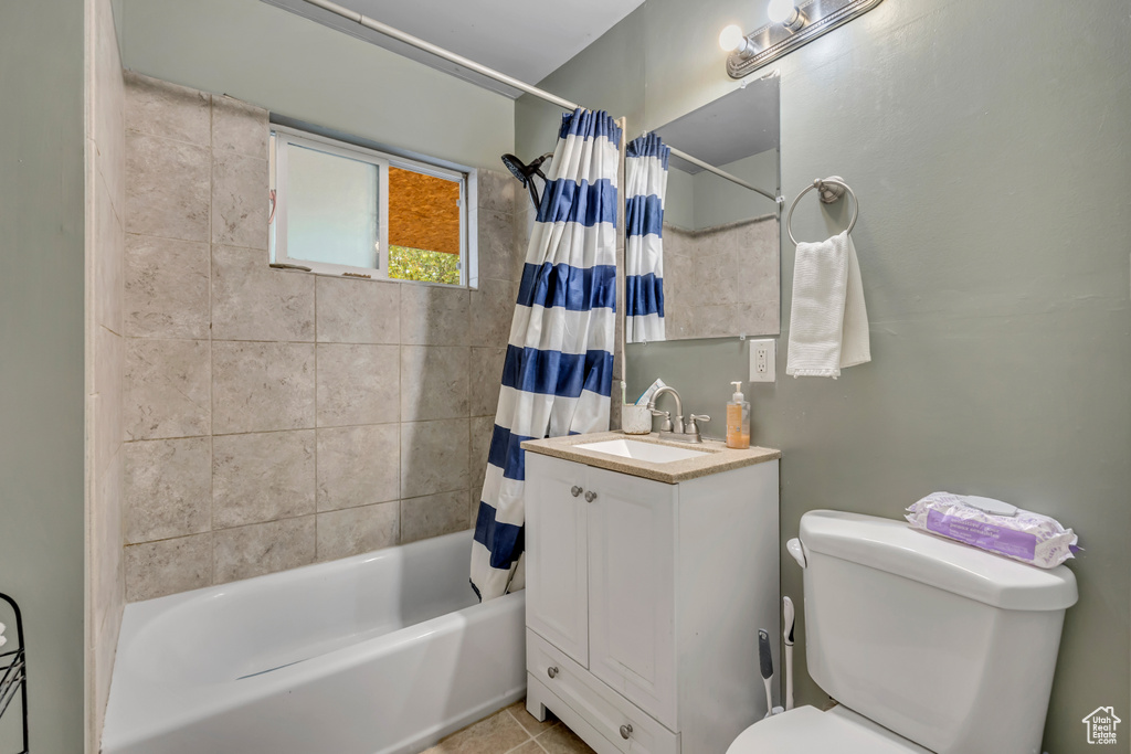Bathroom featuring shower / bath combination with curtain, vanity, and tile patterned floors