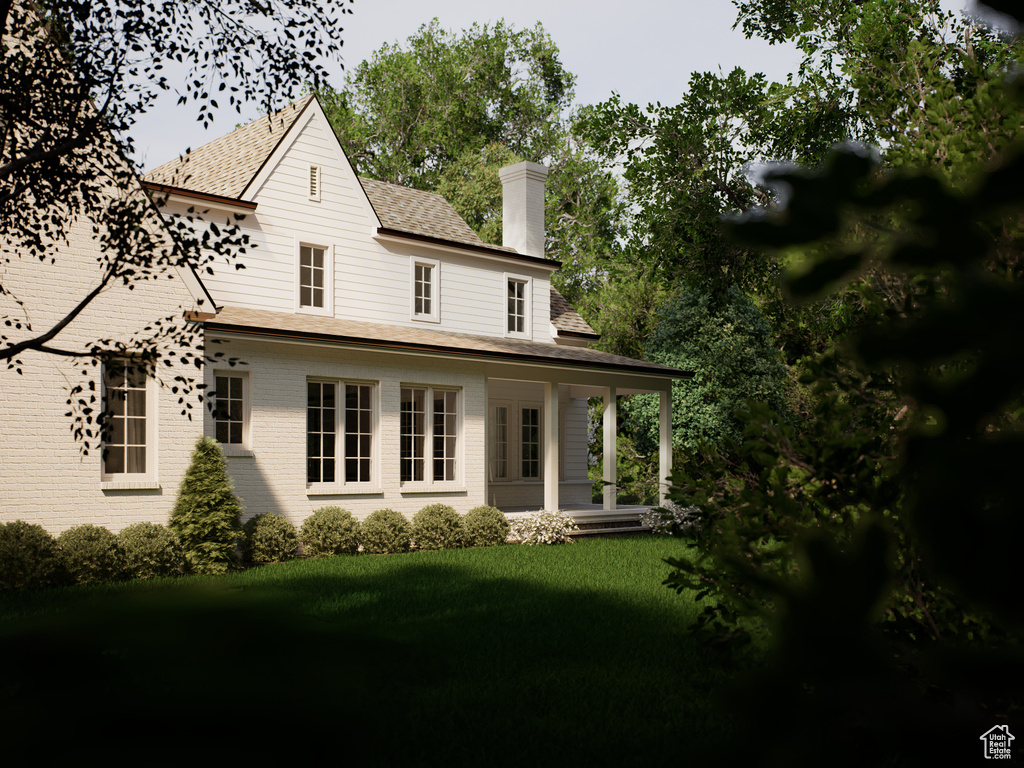 Back of house with a chimney, a lawn, brick siding, and a shingled roof