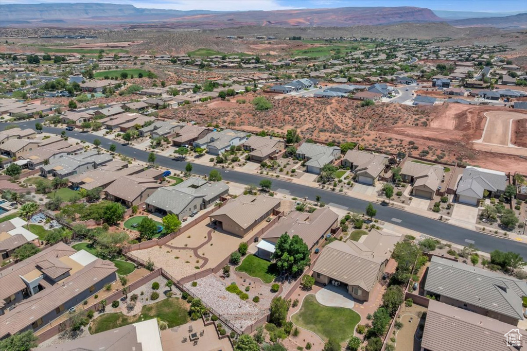 Aerial view of property and surrounding area with mountains and nearby suburban area