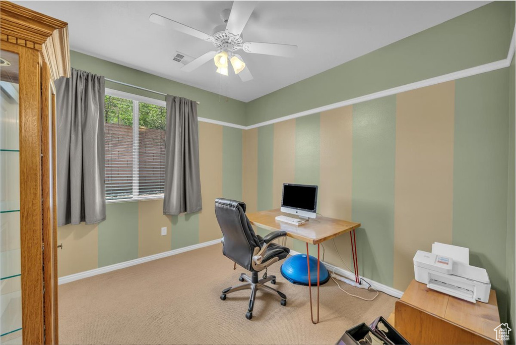 Carpeted office space with baseboards and a ceiling fan