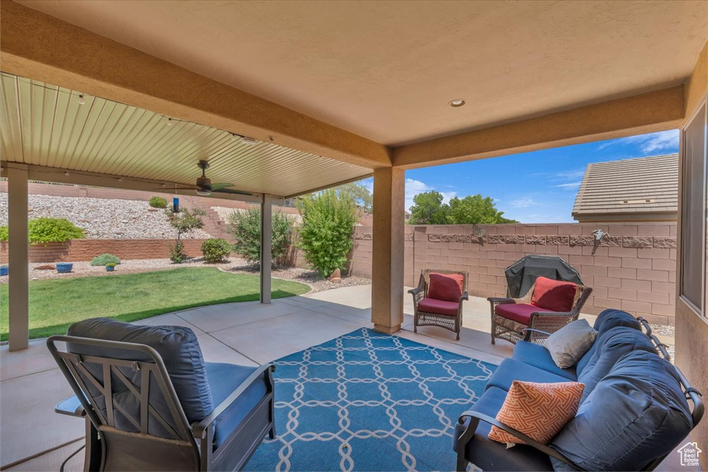 Fenced backyard featuring a patio, ceiling fan, an outdoor living space, and area for grilling