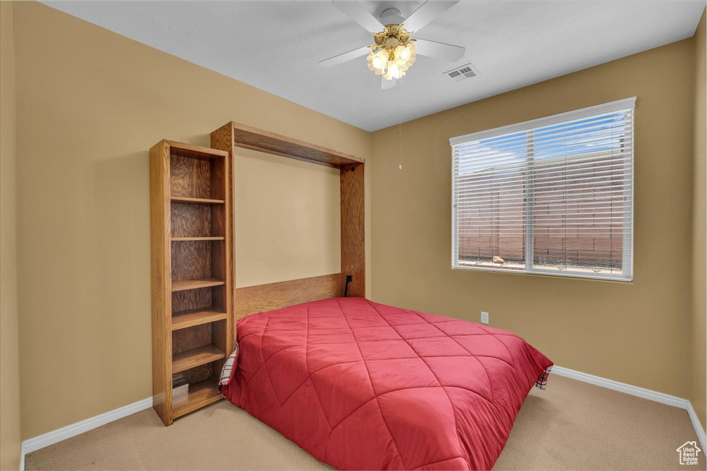 Carpeted bedroom featuring a closet and a ceiling fan