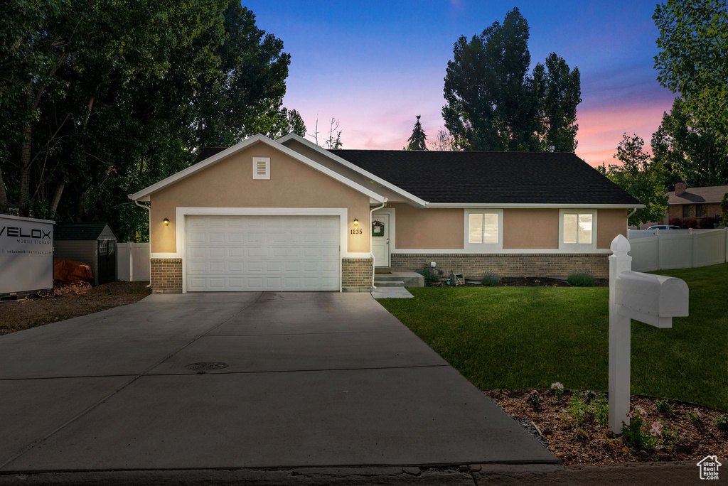 Ranch-style home with concrete driveway, brick siding, stucco siding, and a garage