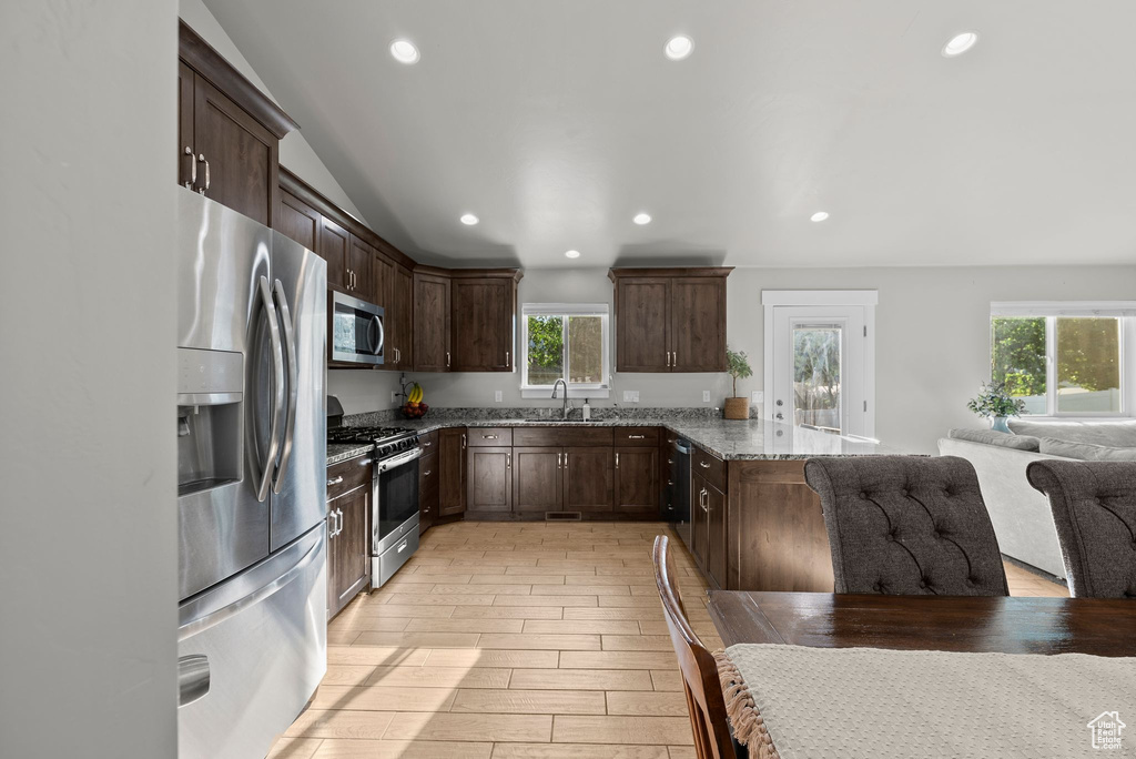 Kitchen with stainless steel appliances, healthy amount of natural light, stone counters, a peninsula, and recessed lighting