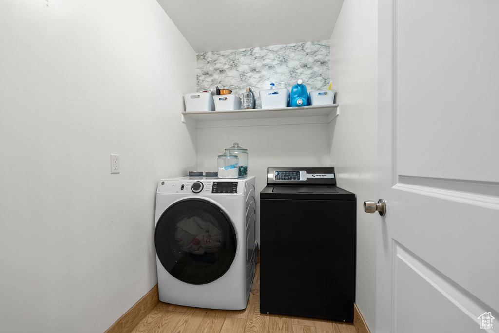 Laundry room featuring separate washer and dryer and light wood-type flooring