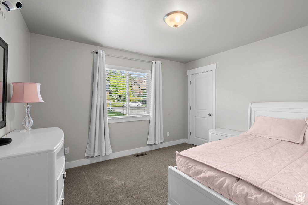 Bedroom featuring dark carpet and baseboards