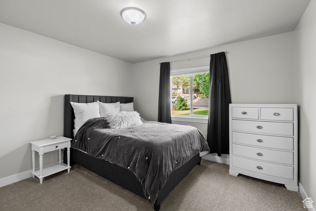 Bedroom featuring carpet and baseboards